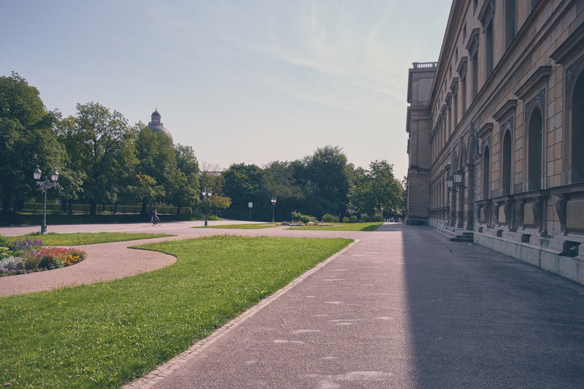 Paved path alongside a building and green park. related to Building a Raised Garden Bed