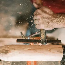 person holding gray metal tool related to Step-by-Step Guide to Crafting a Wooden Bed Frame