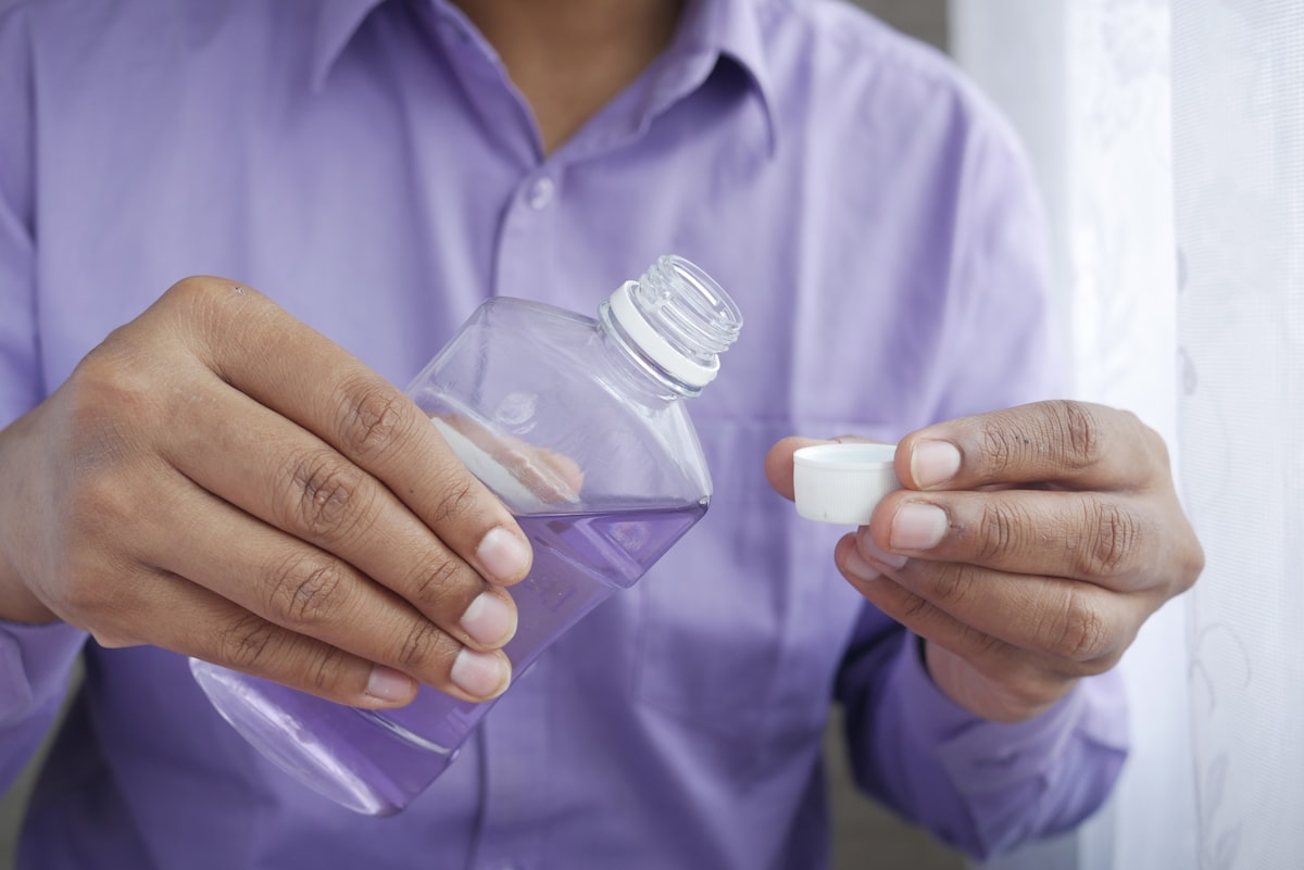 person holding white plastic bottle related to Rubbing Alcohol For Bed Bugs Treatment