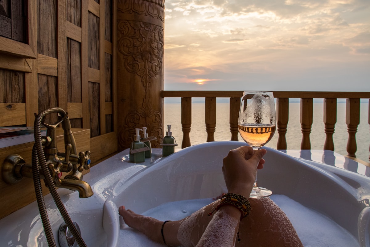 person in bathtub holding wine glass related to Sip in Style: The Ultimate Guide to Bed Bath & Beyond Wine Glasses