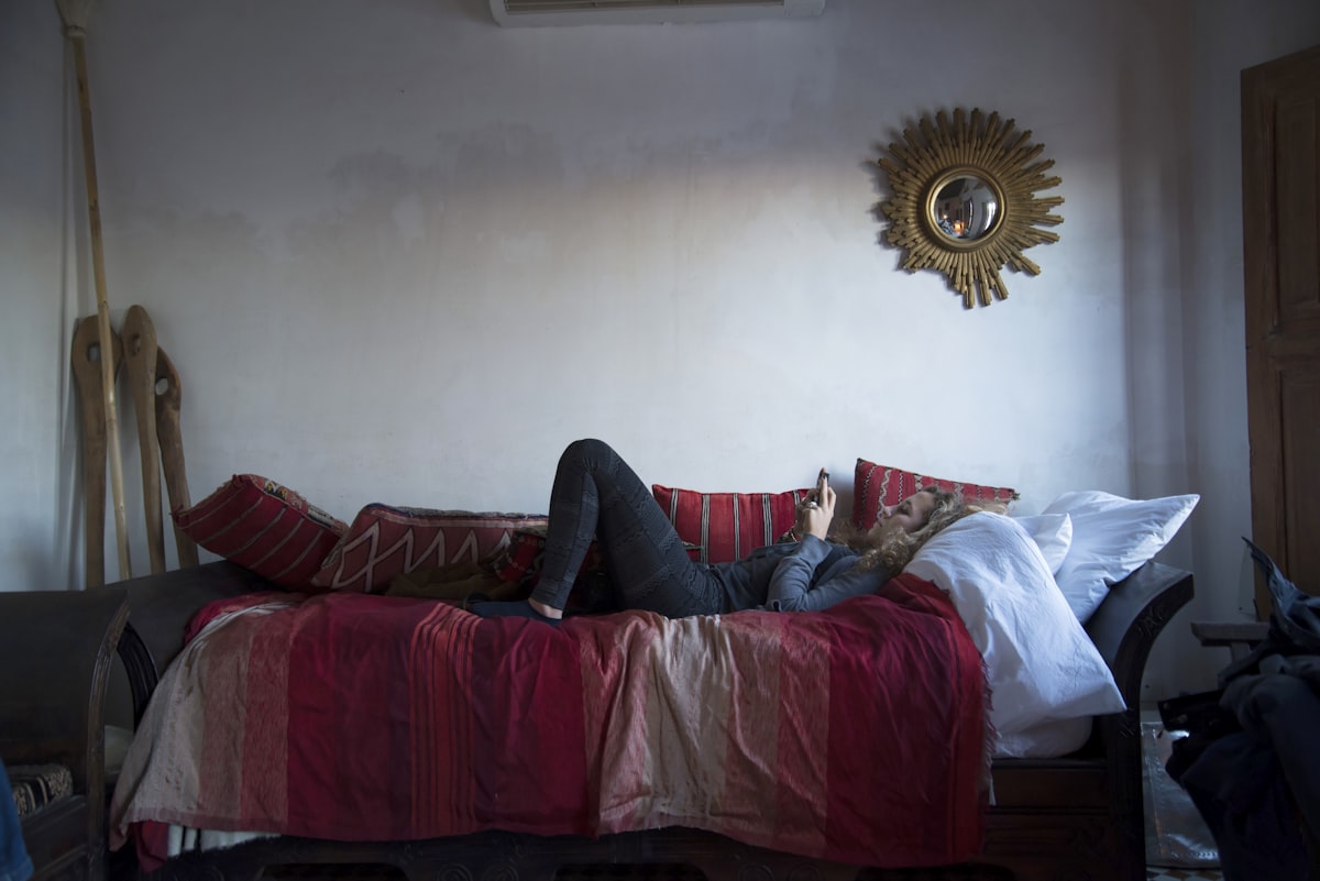 person in blue denim jeans lying on red couch related to Transforming Your Space: The Ultimate Couch to Bed Guide