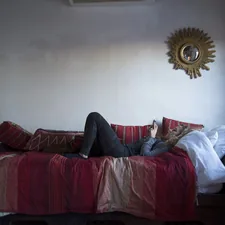 person in blue denim jeans lying on red couch related to Transforming Your Space: The Ultimate Couch to Bed Guide
