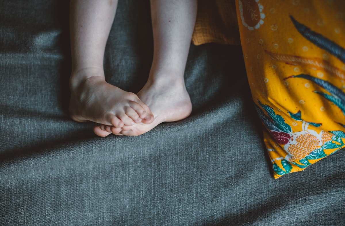 person lying on black textile related to Elevate Your Sleep Experience: The Ultimate Guide to Choosing the Perfect Footstool for Bed