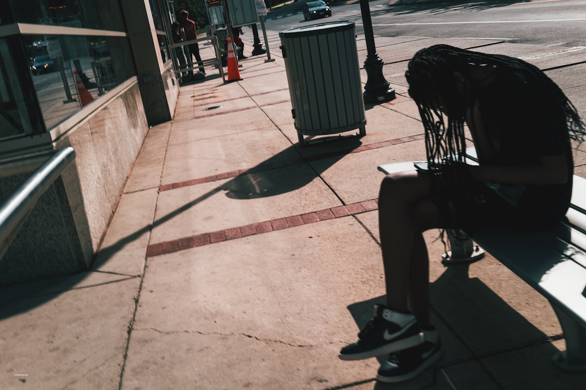 Person sitting on a bench in the sun. related to Styling Your Entryway with the Perfect Bench