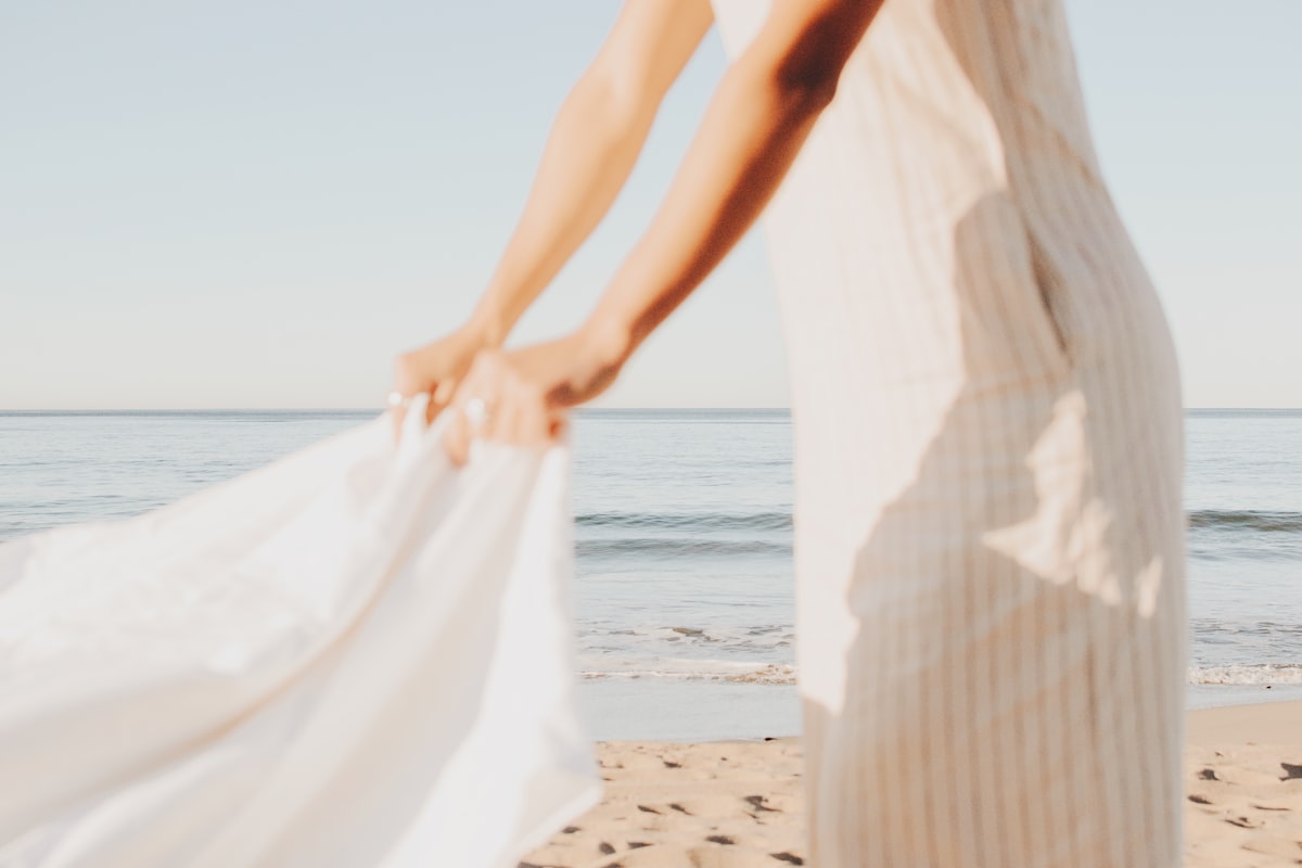 person wearing white dress during daytime related to Embracing Softness: A Guide to Choosing the Perfect Comforters and Coverlets