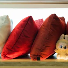 Pillows and a stuffed animal rest on a shelf. related to The Ultimate Guide to Bed Bath and Beyond Cushions: Comfort and Style Combined