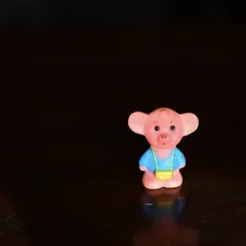 pink bear plastic toy on brown wooden table related to The Adventures of Curious George: The Ultimate Toddler Bedding Guide