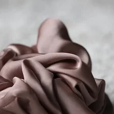 Pink fabric is artfully draped. related to The Ultimate Guide to Silk Bedding Sets