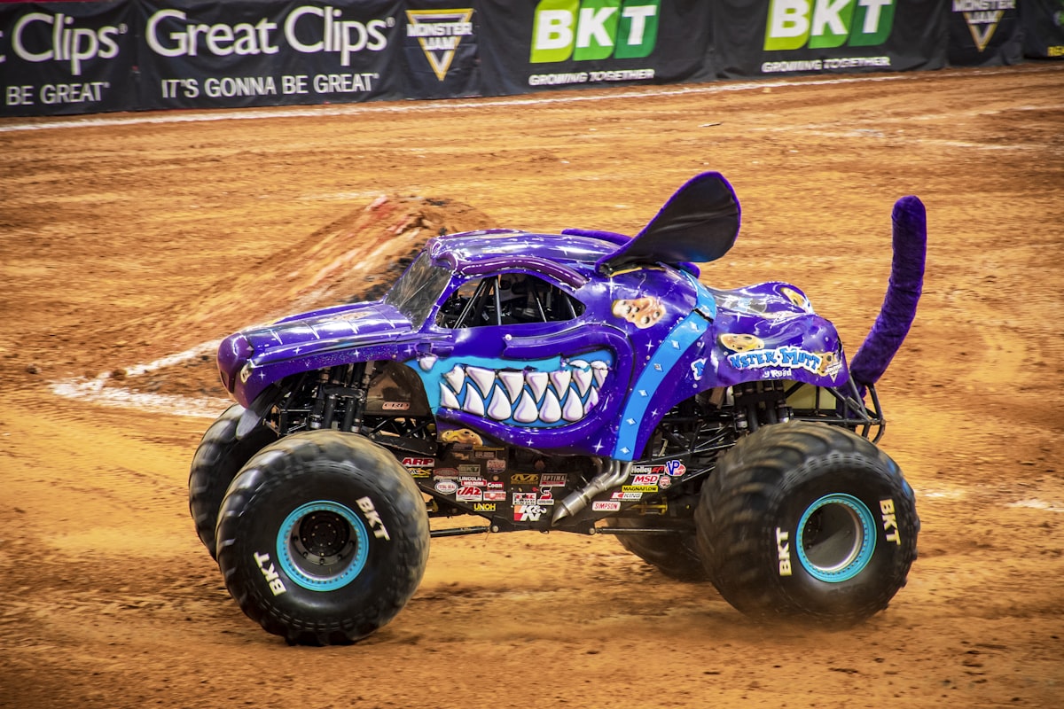 purple and black monster truck on brown sand related to Monster Jam: Bring Thrilling Racing Action to Your Bedtime