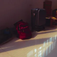 Red backpack and other bags on a sunlit floor. related to Top Picks for Luggage at Bed Bath & Beyond