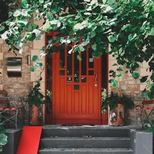 Red door from an overgrown house related to Elevate Your Entrance: Decorating with Entryway Tables and Mirrors