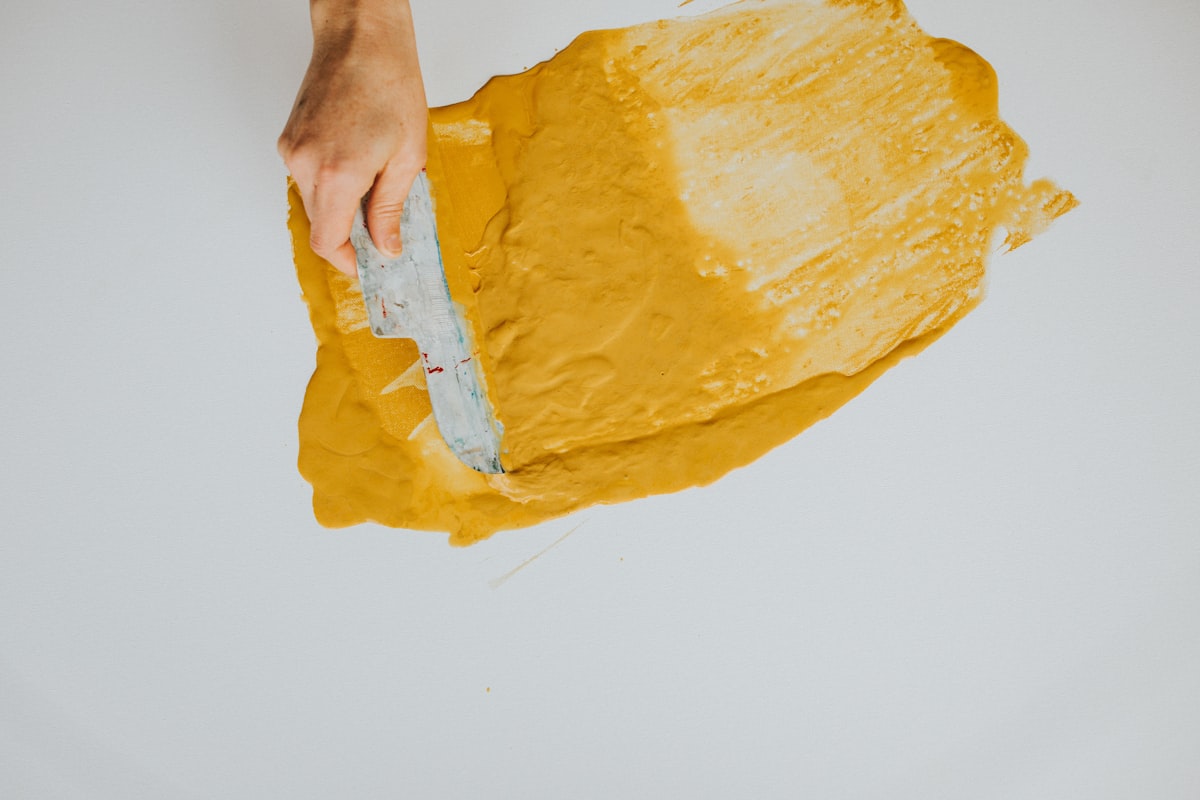 spreading yellow paint on a white canvas. Acrylic pour. Redding local artist @artofdawn related to Latex-Free Coverlet Adhesive Dressings for Sensitive Skin