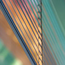 Stack of tinted glass panes with reflections related to Revealing the Anatomy of Vertical Blind Valance Parts