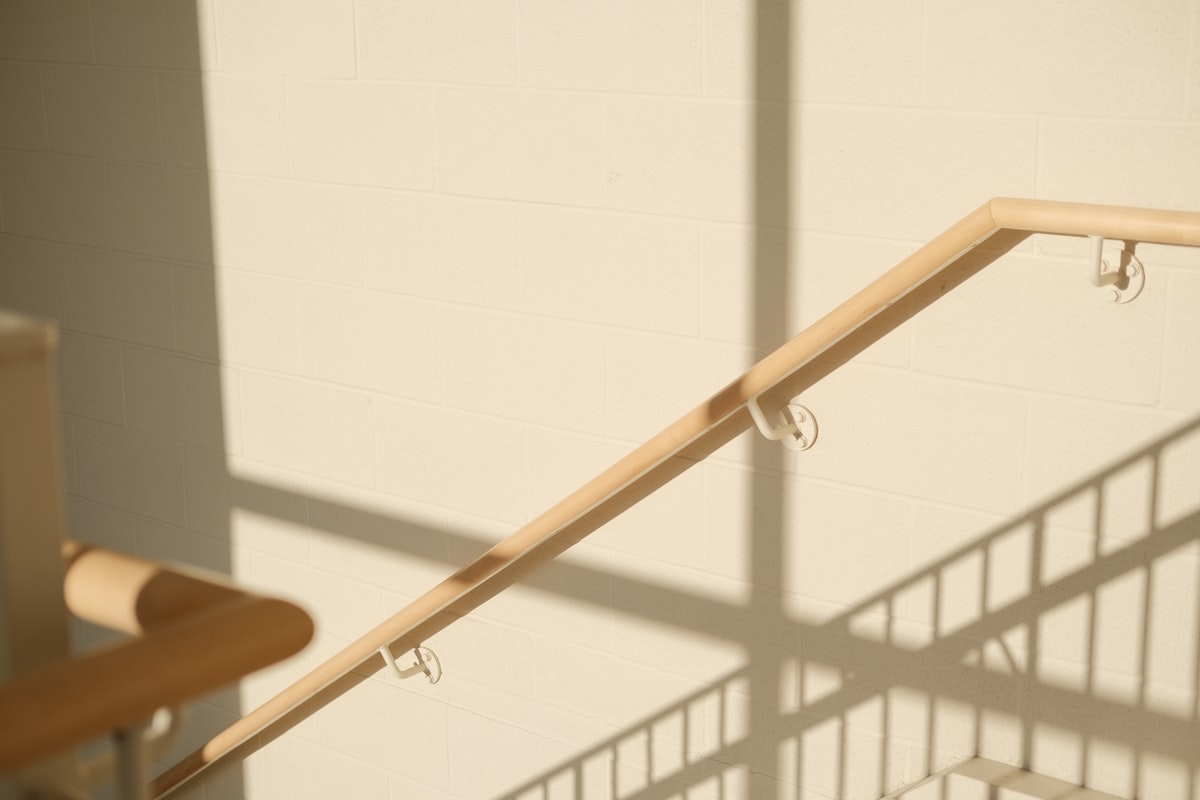 Staircase with railing casting shadows on the wall. related to Introducing the Ultimate Bed Rail Hooks