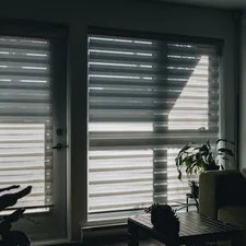 Sunlight shines through a window with blinds. related to Zebra Valance Curtains: A Stylish Twist to Window Decor