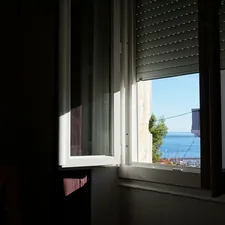 Sunlight streams through an open window onto the sea. related to Coastal Window Valances