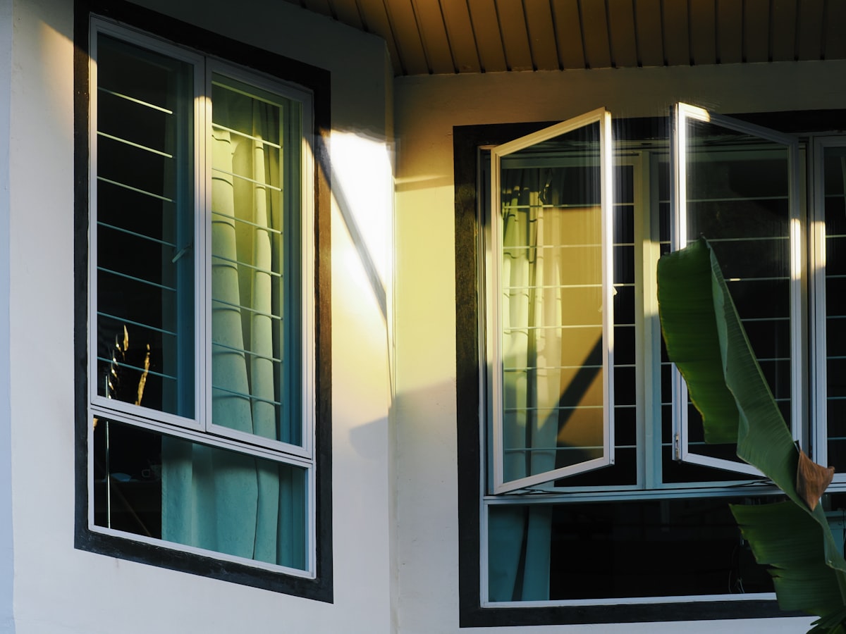 Sunlight streams through open windows on a building. related to Cheap Window Valances | Affordable Window Treatments