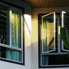 Sunlight streams through open windows on a building. related to Cheap Window Valances | Affordable Window Treatments