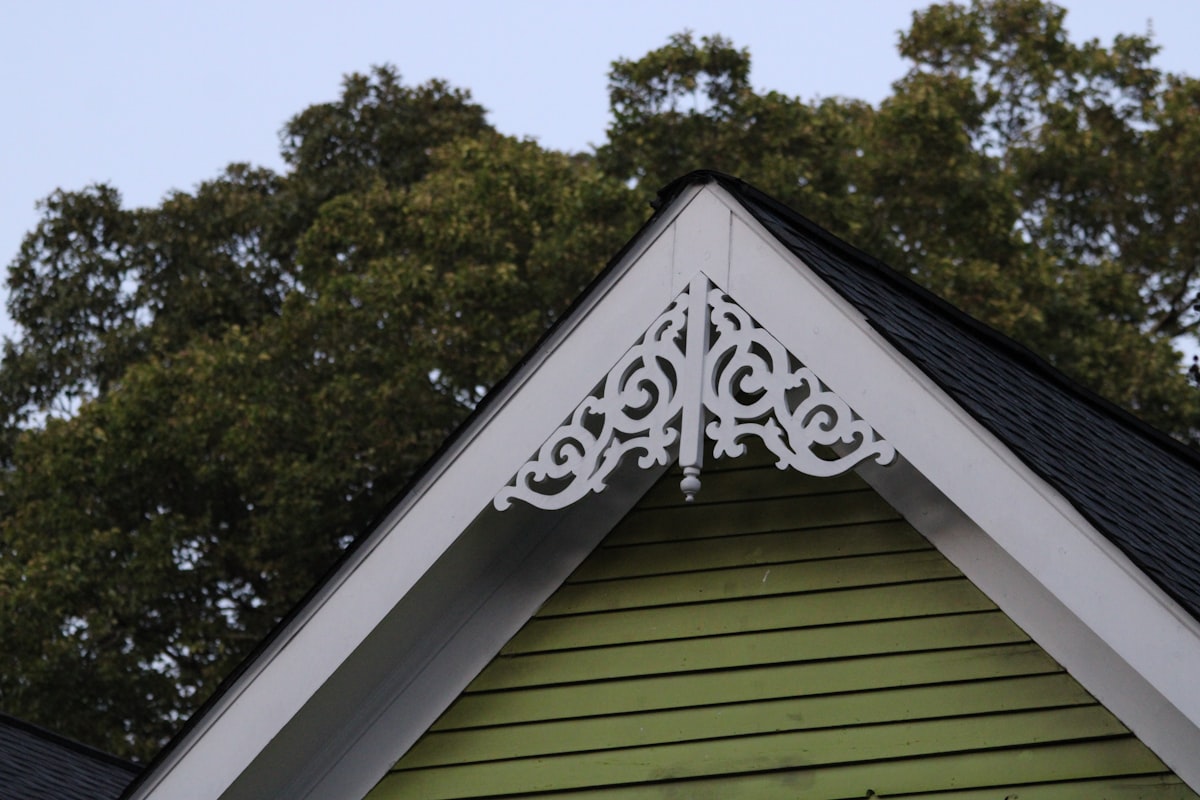 The top of a green wooden house with trees behind it in Atlanta, Georgia, USA. Photographed by Mark Stuckey. related to What is a Cornice Valance?
