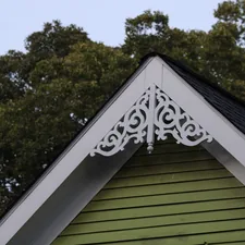 The top of a green wooden house with trees behind it in Atlanta, Georgia, USA. Photographed by Mark Stuckey. related to What is a Cornice Valance?