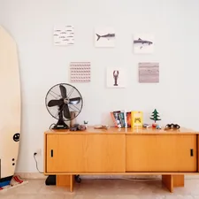 This is my place that i added on Airbnb & Booking (i named it: Family and Relax)

That is my first surfboard which was 8 foot and after crashing on a reef it became 7 foot :)

The fan is really old and belonged to my grandfather.

The wooden furniture, binoculars is pretty old and was in my uncles office until he retired.

Frames on the wall are from IKEA.

Books (Simplicity, Gamification, Reality is Broken, The hundred year old man that climb through the window and disappeared, Hero) related to The Ultimate Guide to Sideboards and Buffets