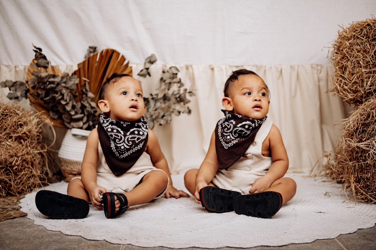Twin babies are sitting in a rustic style. related to Western Baby Bedding Essentials