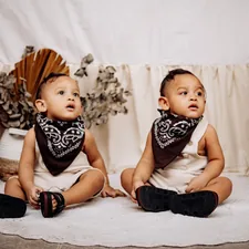 Twin babies are sitting in a rustic style. related to Western Baby Bedding Essentials