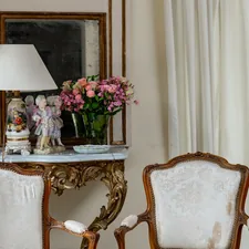 two chairs and a table with a vase of flowers on it related to Statement Draperies: Embrace Elegance with Contemporary Curtain Valances