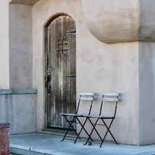 Two chairs in front of an old wooden door related to Beyond the Basics:  Unique Entryway Benches That Make a Statement
