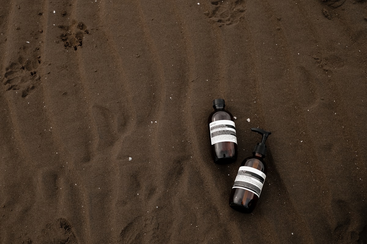 two empty beer bottles laying on a beach related to Top Tanning Bed Lotions for a Perfect Glow