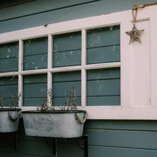 two metal planters sitting next to a window related to Elevate Your Window Style with Pottery Barn Window Valances