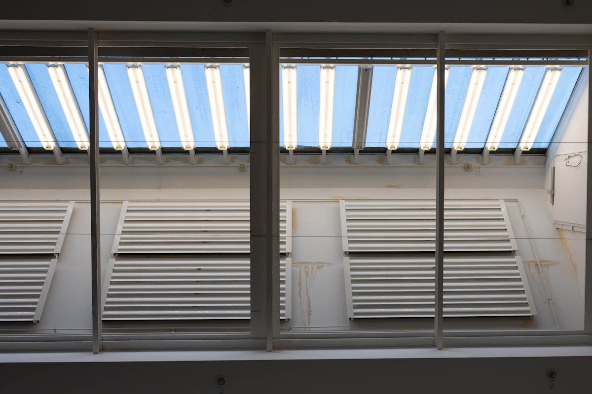Two rows of white louvers under a striped awning. related to Mock Roman Valances