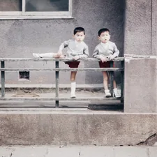Two young boys sitting on a bench in front of a building related to Understanding the Width of a Twin Size Bed