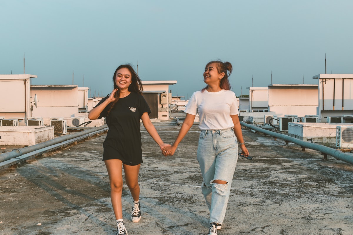 two young women holding hands while walking on a roof related to Mastering the Art of Building a Twin Bed Frame: A Step-by-Step Guide