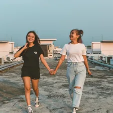 two young women holding hands while walking on a roof related to Mastering the Art of Building a Twin Bed Frame: A Step-by-Step Guide