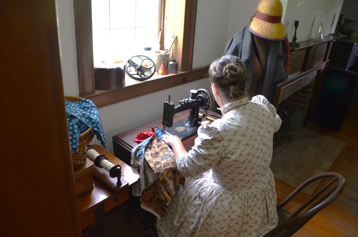 Volunteer at Historical farm sewing on treadle sewing machine related to Making a Valance