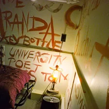 Wall covered in orange graffiti and writing. related to Unleashing Your Bedroom's Potential: Unique Bed Frames