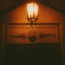 Warm lantern light illuminates a decorative lion head carving. related to Illuminating the First Impression: Entryway Light Fixture Ideas