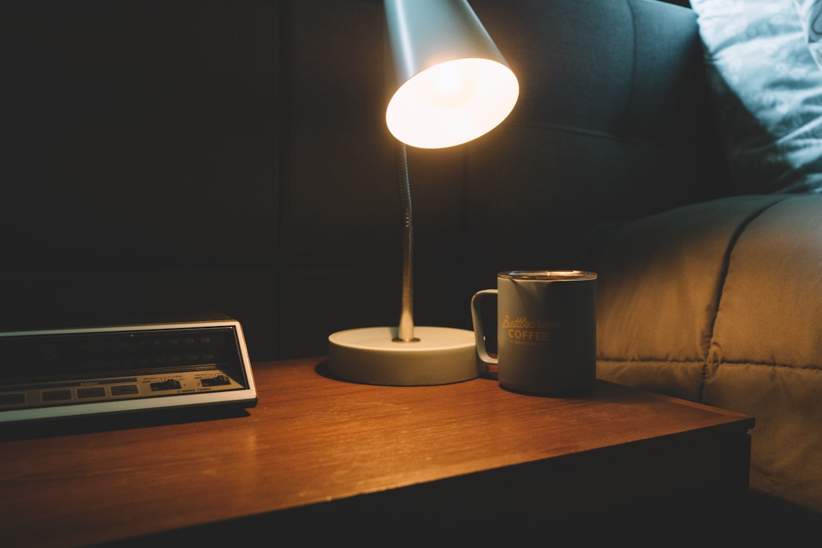 white and black ceramic mug beside white ipad on brown wooden table related to The Perfect Bedtime Companion