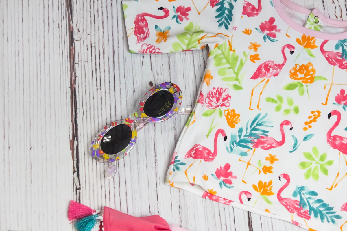 white and multicolored crew-neck shirt near sunglasses related to Transform Your Nursery with Flamingo Crib Bedding
