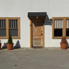 White building facade with wooden door and windows related to Elevate Your Entryway: The Ultimate Guide to Window Curtains