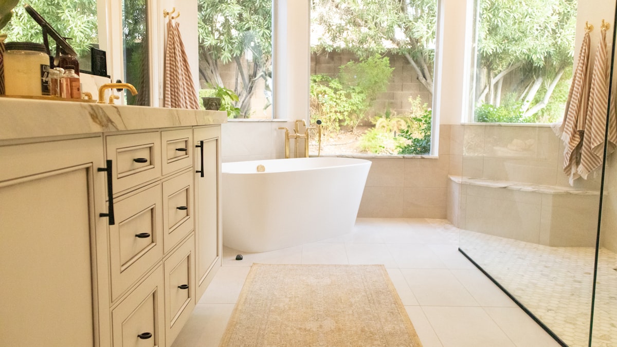 white ceramic bathtub near white wooden cabinet related to Elevate Your Bathroom Style with Shower Curtains featuring Valances