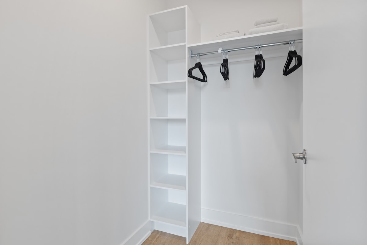 white wooden shelf with black and white shoes related to Revamping Your Entryway with a Smart Entryway Coat Closet