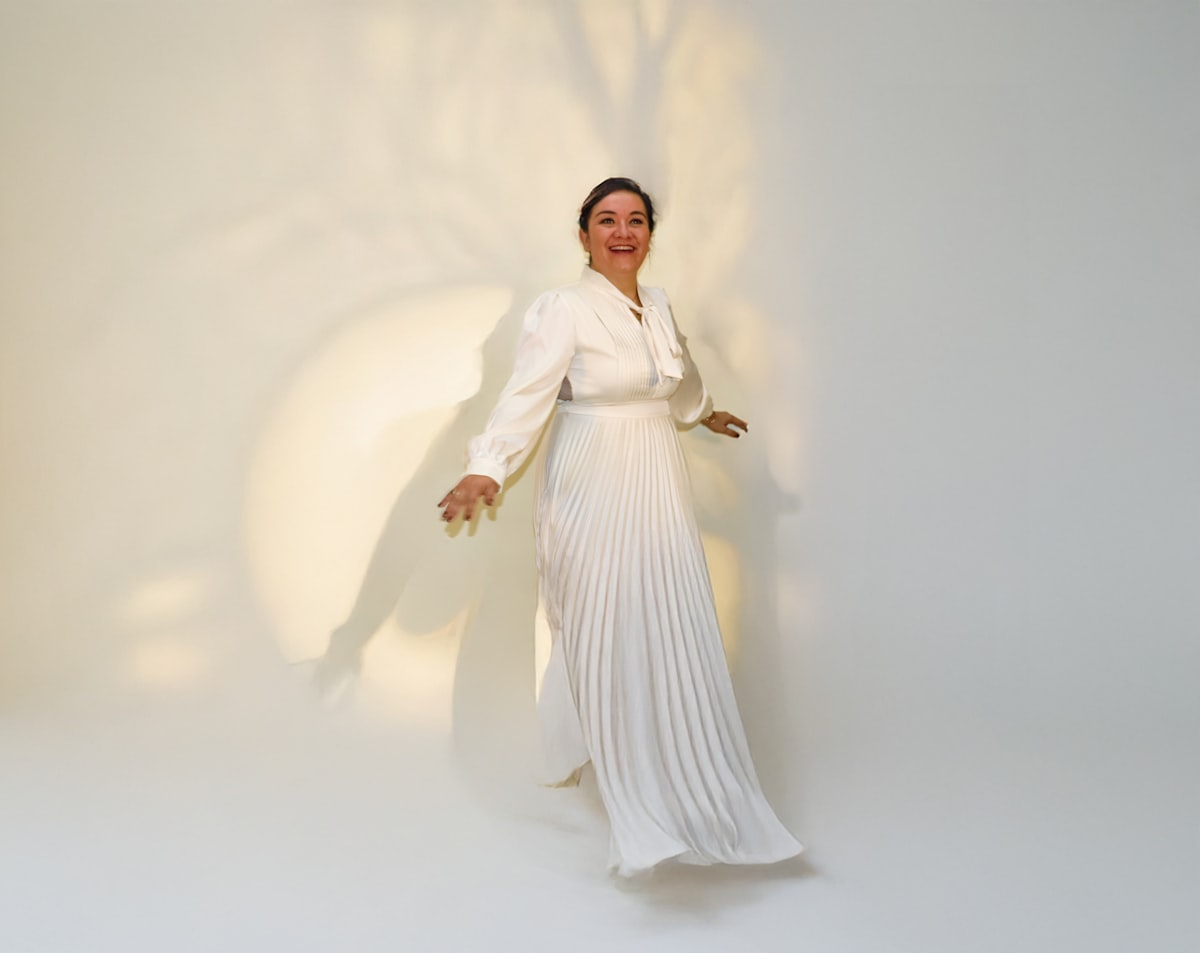 Woman in elegant white dress with pleated skirt related to Elegance Defined: White Tie Up Valance Curtains