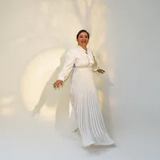 Woman in elegant white dress with pleated skirt related to Elegance Defined: White Tie Up Valance Curtains