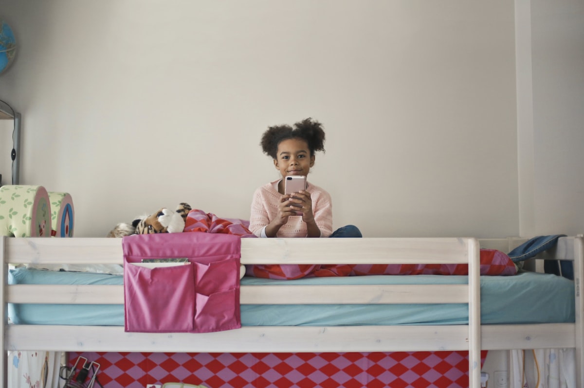 woman in yellow long sleeve shirt sitting on bed related to Bunk Beds for Kids: Transforming Sleep Into Adventure