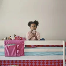 woman in yellow long sleeve shirt sitting on bed related to Bunk Beds for Kids: Transforming Sleep Into Adventure