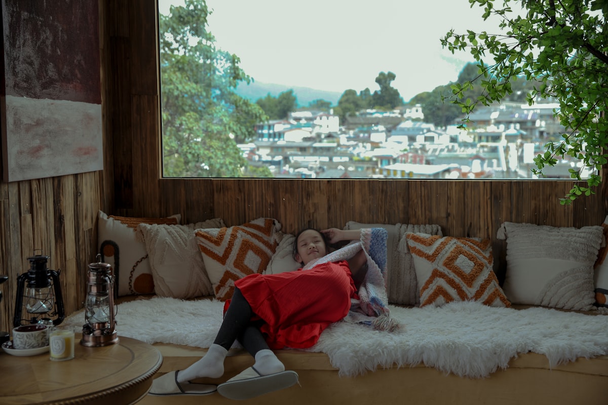 Woman relaxing on a couch with a scenic view. related to Your Mountain Escape Awaits at Comfort Bed and Breakfast