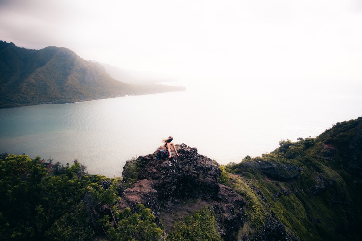 woman sitting on cliff related to Discover the Charm of Hawaii's Bed and Breakfasts