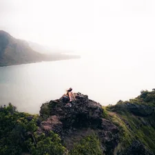 woman sitting on cliff related to Discover the Charm of Hawaii's Bed and Breakfasts